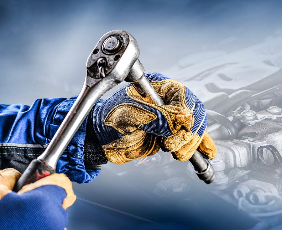 Blau-gelber Handschuh, der einen Schraubschlüssel hält