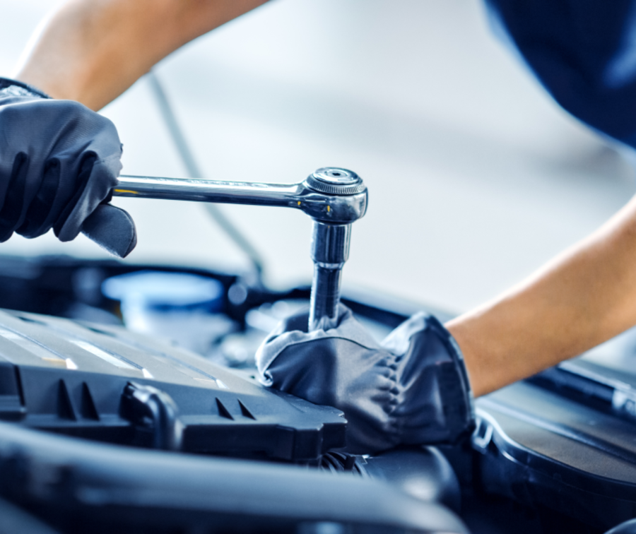 Ein Mechaniker beschäftigt sich mit dem Motor eines Fahrzeugs